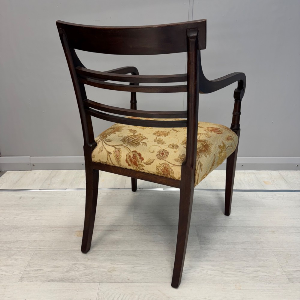 A dark mahogany Regency carver armchair featuring reeded scrolled arms, horizontal slat backrest, fluted front legs, and a golden floral patterned upholstered seat. View VII