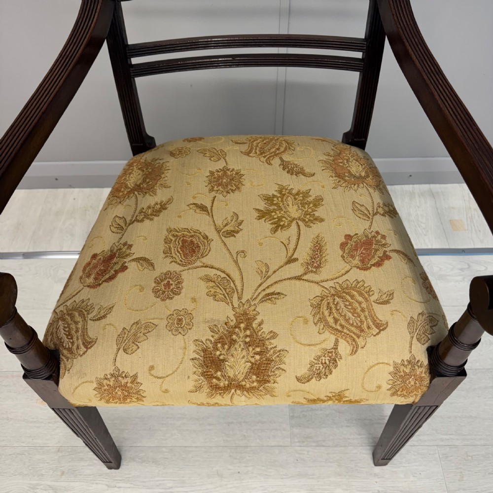 A dark mahogany Regency carver armchair featuring reeded scrolled arms, horizontal slat backrest, fluted front legs, and a golden floral patterned upholstered seat. View VIII