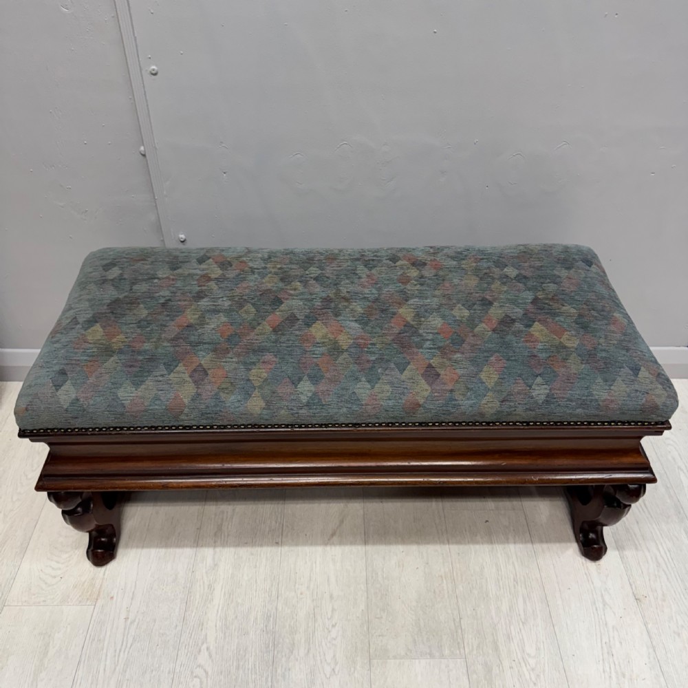 A Victorian mahogany piano duet stool featuring a patterned upholstered hinged top, brass studding, carved cabriole legs, and a turned stretcher base. View III