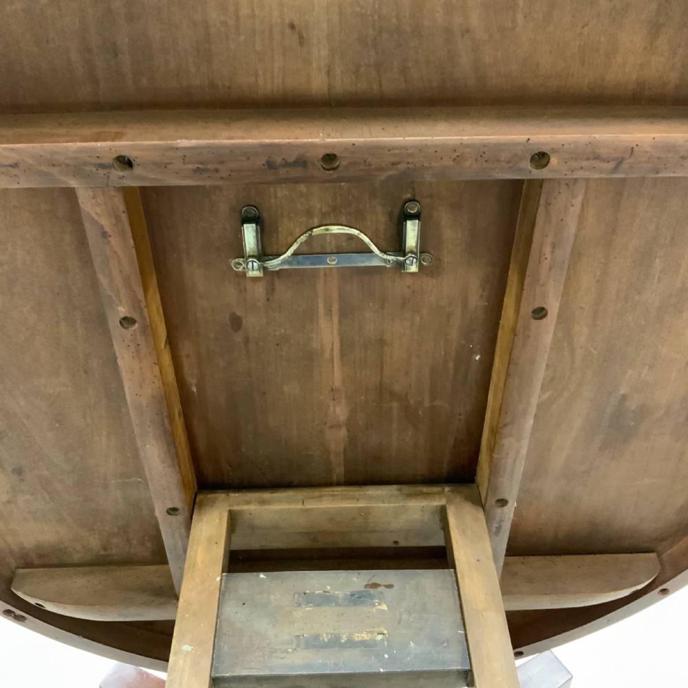 A circular Regency mahogany centre table featuring a smooth timber top supported on a central pedestal and a concave triform base with ball feet. View IV