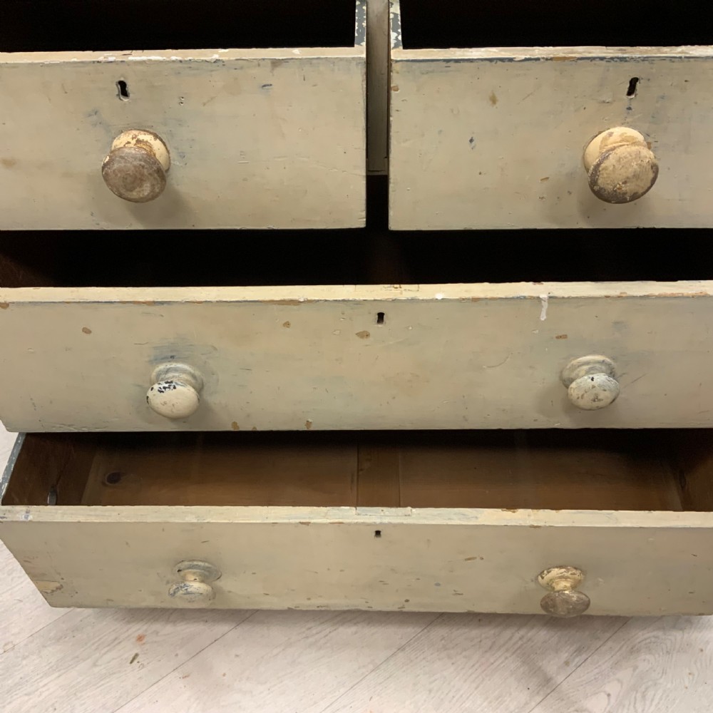 A 19th-century painted pine chest of drawers featuring two short over two long drawers, turned wooden knobs, turned bun feet, and a distressed cream painted finish. View VIII