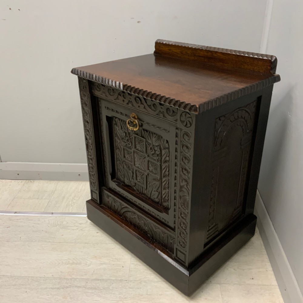 An Edwardian carved dark oak Purdonium coal box featuring a drop-front compartment, internal metal liner, and an included metal shovel with a wooden handle. View II