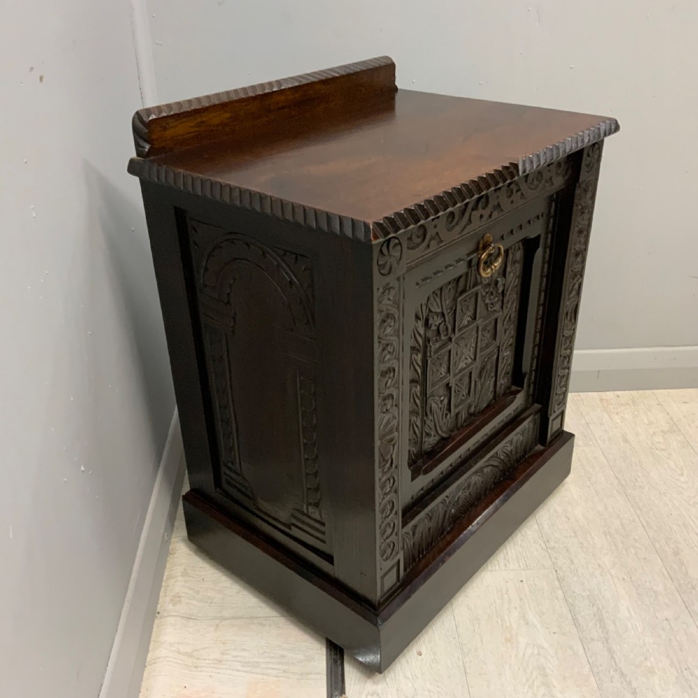 An Edwardian carved dark oak Purdonium coal box featuring a drop-front compartment, internal metal liner, and an included metal shovel with a wooden handle. View III