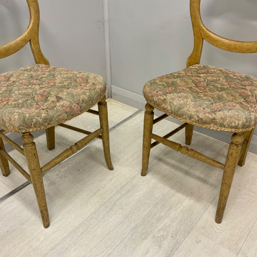 A pair of antique Victorian balloon back side chairs featuring ochre scumble glazed wood frames, turned legs, and floral tapestry upholstered seats. View II