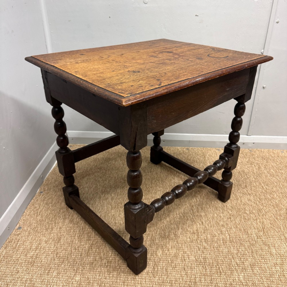 A 17th-century dark oak side table with a rectangular top, bobbin-turned legs, and connecting stretchers. View II