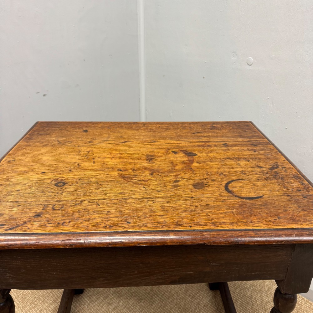 A 17th-century dark oak side table with a rectangular top, bobbin-turned legs, and connecting stretchers. View III