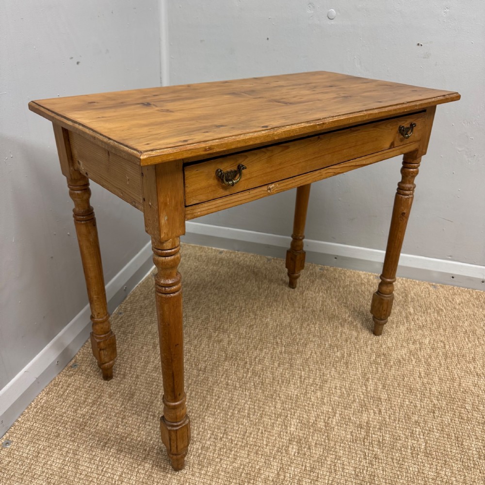 A 19th-century Victorian pine side table with turned legs and a single frieze drawer fitted with brass handles.