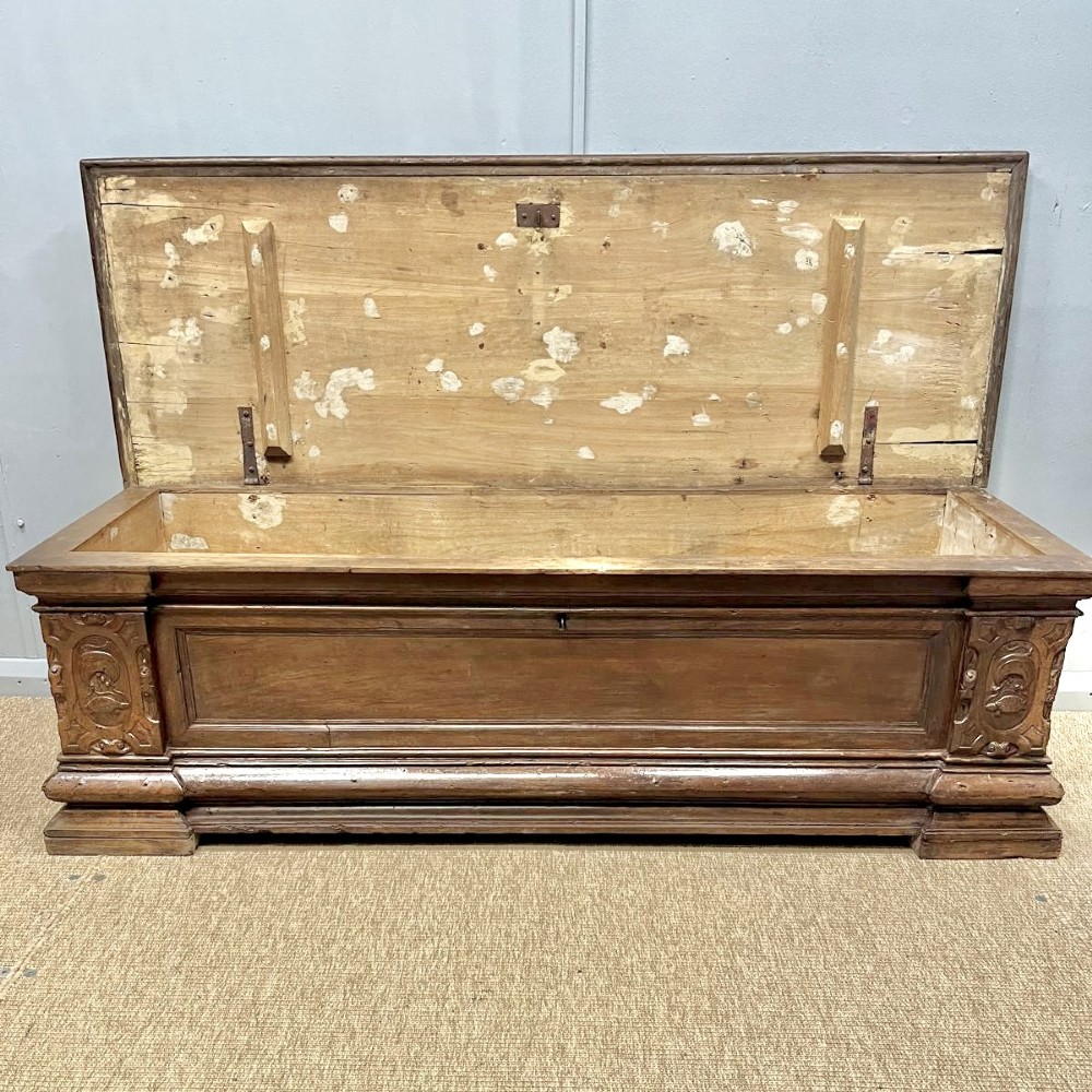 A large 17th-century Italian walnut marriage chest featuring carved corner pilasters, recessed front panels, and a plinth base. View IV
