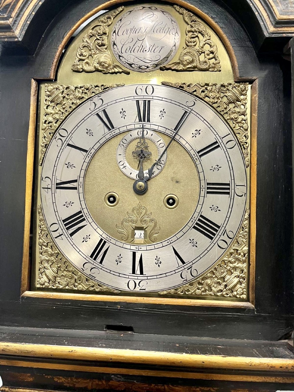 An 18th-century black lacquered longcase clock featuring gilt chinoiserie artwork, brass finials, and an arched brass dial. View IV
