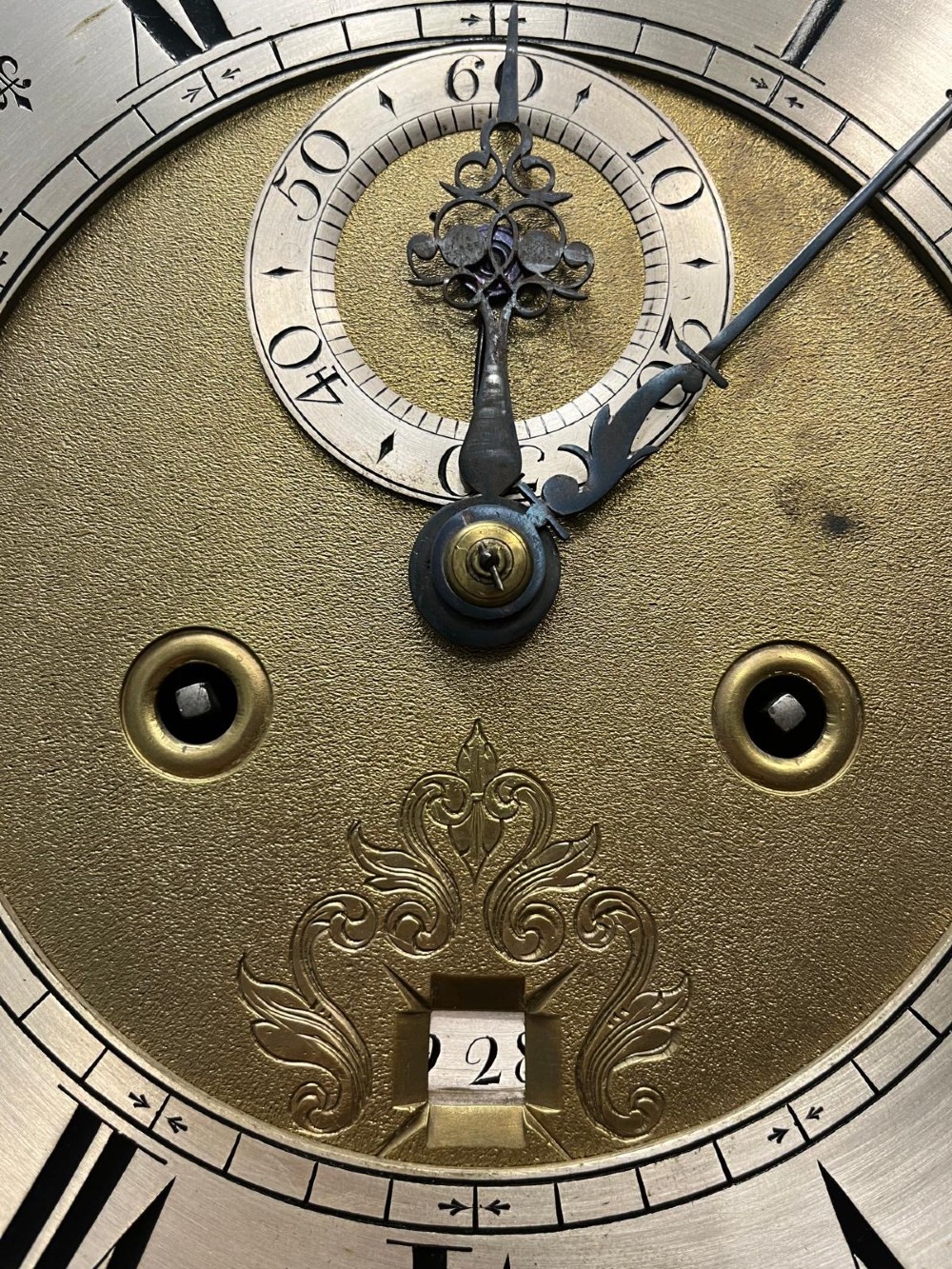 An 18th-century black lacquered longcase clock featuring gilt chinoiserie artwork, brass finials, and an arched brass dial. View VII