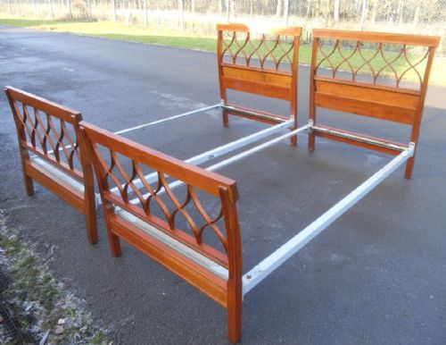 fig 1. A pair of Edwardian inlaid mahogany single bed frames featuring geometric openwork headboards and footboards.