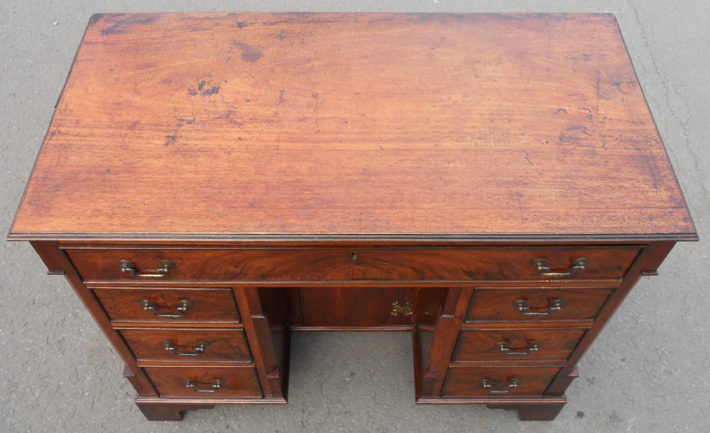 A Georgian style mahogany kneehole writing desk featuring multiple drawers with brass swan-neck handles and a recessed central cupboard on bracket feet. View III