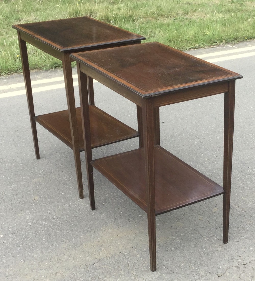 A pair of rectangular Edwardian mahogany occasional tables featuring fine line inlay, tapered legs, and lower tier shelves.