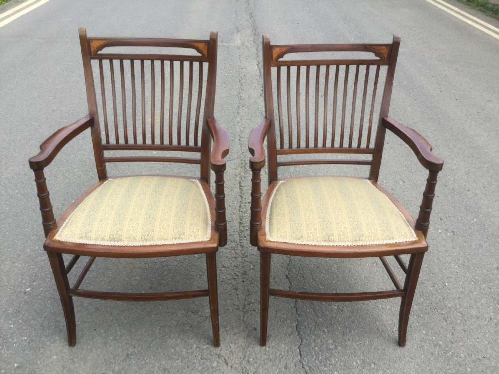 A pair of Edwardian mahogany salon armchairs featuring vertical slatted backs with marquetry inlay details on the top rail and upholstered patterned seats. View II
