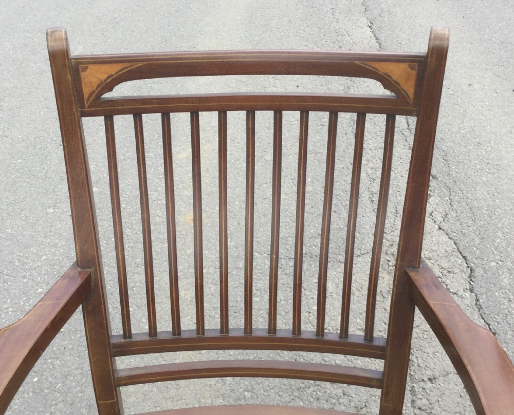 A pair of Edwardian mahogany salon armchairs featuring vertical slatted backs with marquetry inlay details on the top rail and upholstered patterned seats. View IV