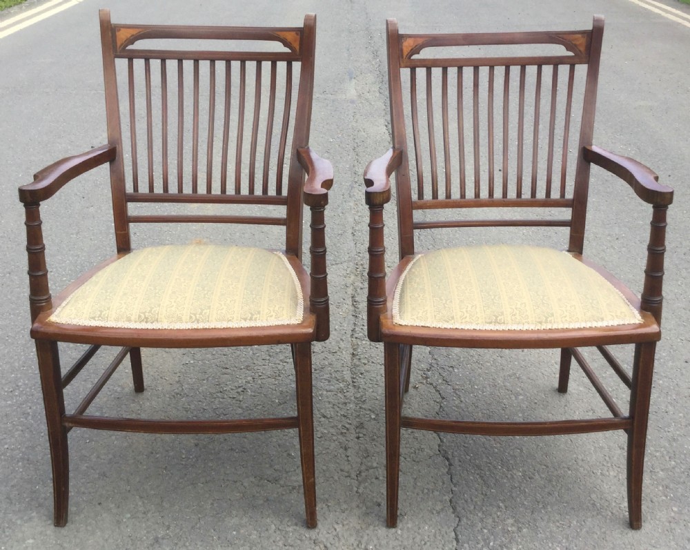 A pair of Edwardian mahogany salon armchairs featuring vertical slatted backs with marquetry inlay details on the top rail and upholstered patterned seats. View VI