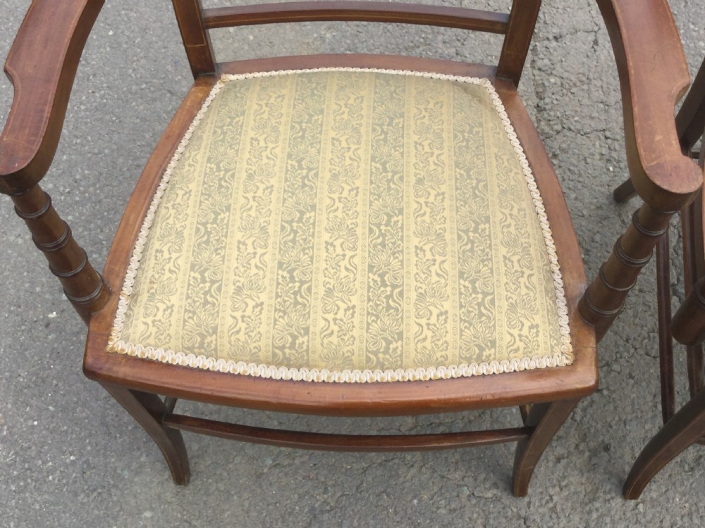 A pair of Edwardian mahogany salon armchairs featuring vertical slatted backs with marquetry inlay details on the top rail and upholstered patterned seats. View VII