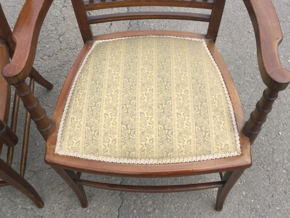 A pair of Edwardian mahogany salon armchairs featuring vertical slatted backs with marquetry inlay details on the top rail and upholstered patterned seats. View VIII