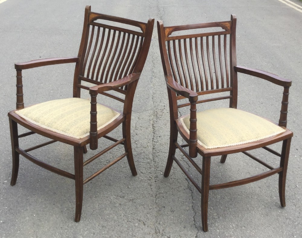 A pair of Edwardian mahogany salon armchairs featuring vertical slatted backs with marquetry inlay details on the top rail and upholstered patterned seats. View IX