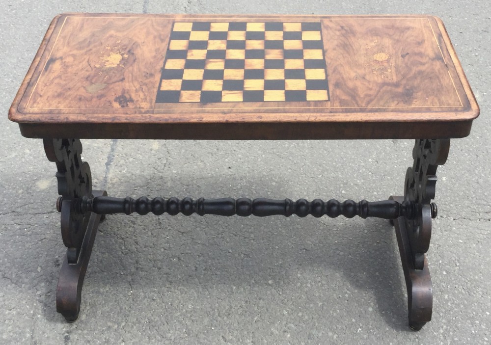 A rectangular Victorian walnut games table featuring a central inlaid chessboard, marquetry side panels, carved trestle ends, and a turned stretcher. View II