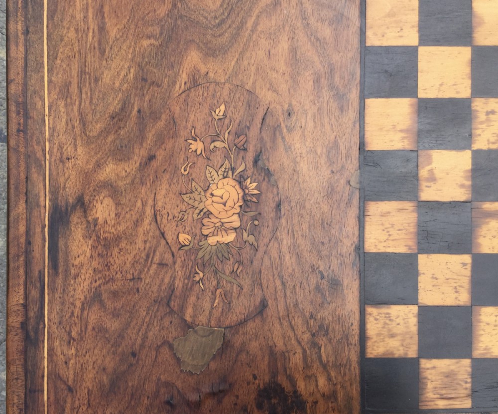 A rectangular Victorian walnut games table featuring a central inlaid chessboard, marquetry side panels, carved trestle ends, and a turned stretcher. View IX