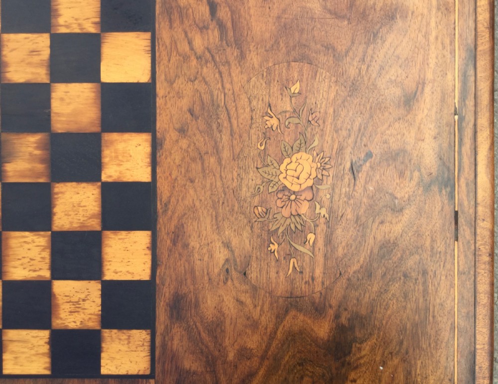 A rectangular Victorian walnut games table featuring a central inlaid chessboard, marquetry side panels, carved trestle ends, and a turned stretcher. View X