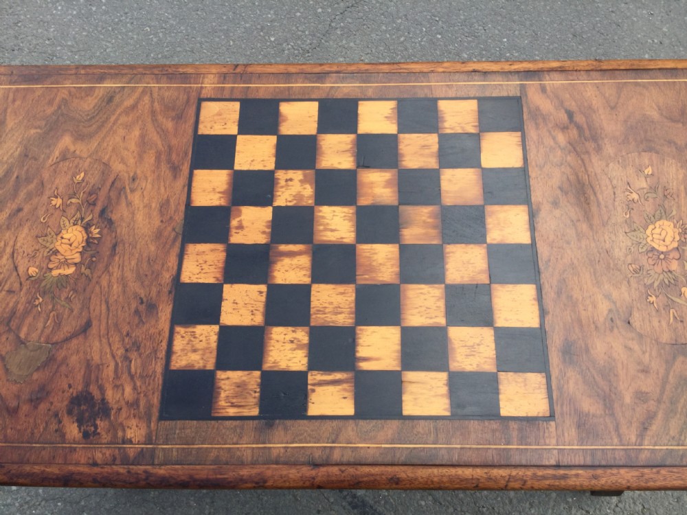 A rectangular Victorian walnut games table featuring a central inlaid chessboard, marquetry side panels, carved trestle ends, and a turned stretcher. View XI