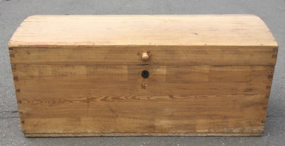 A large rectangular natural pine blanket chest with a rounded domed lid, corner dovetail joints, a central wooden knob, and an iron escutcheon. View II