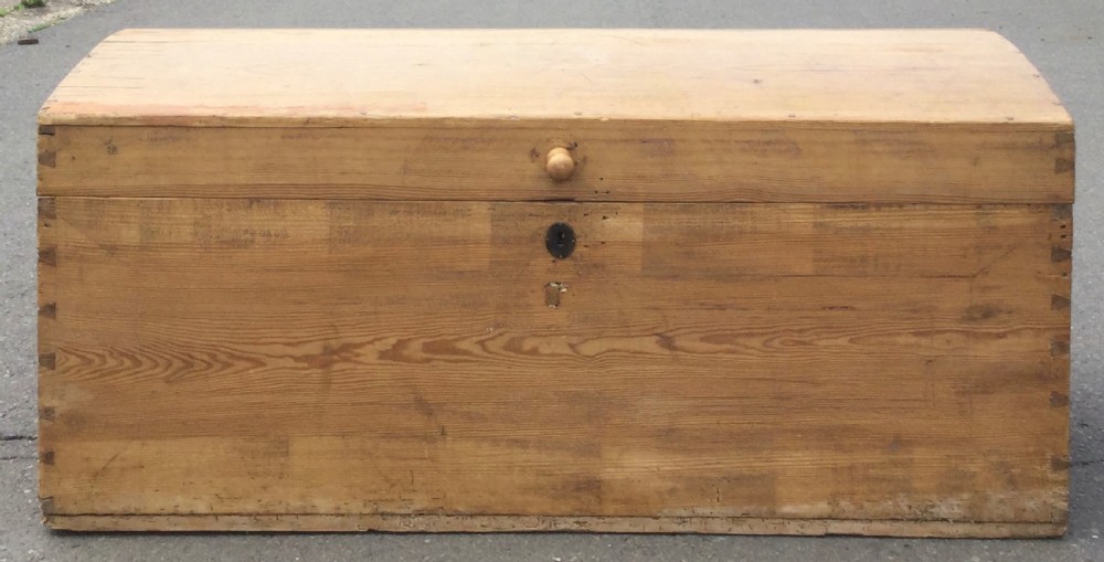 A large rectangular natural pine blanket chest with a rounded domed lid, corner dovetail joints, a central wooden knob, and an iron escutcheon. View VII