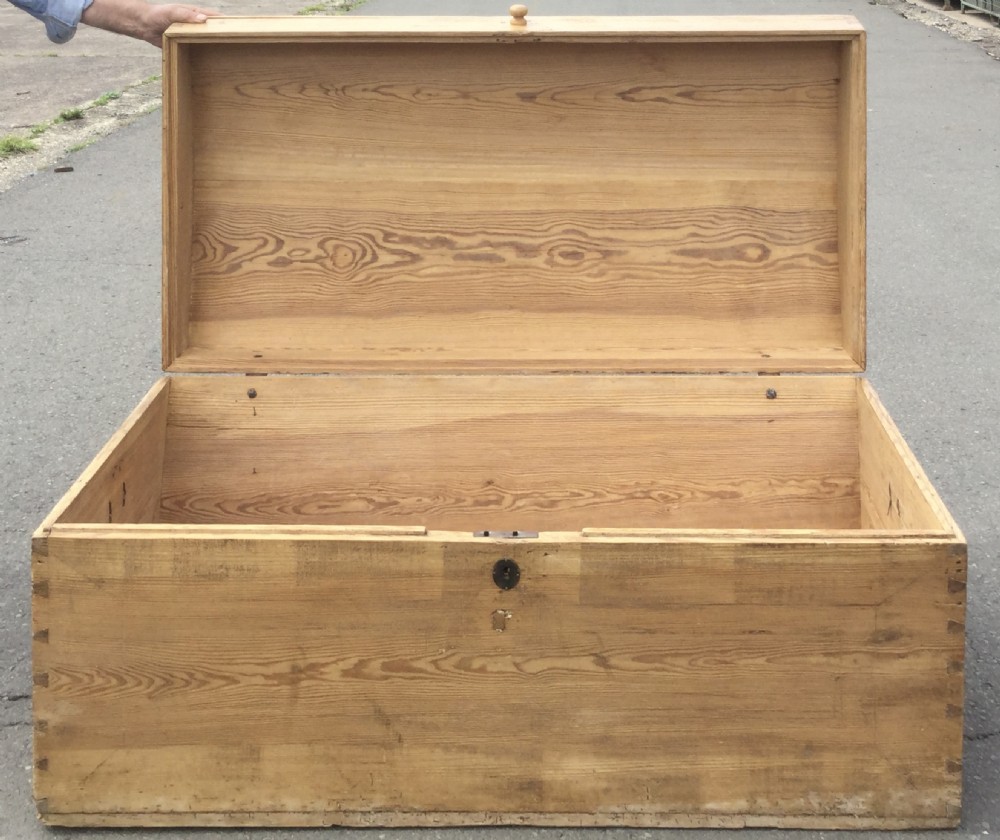 A large rectangular natural pine blanket chest with a rounded domed lid, corner dovetail joints, a central wooden knob, and an iron escutcheon. View VIII