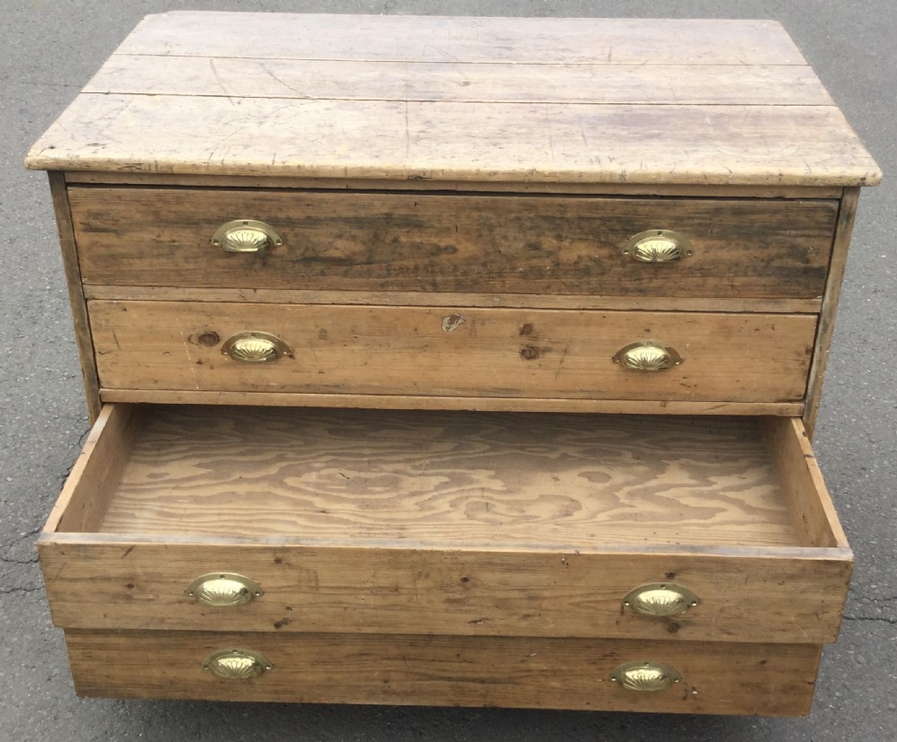 An Edwardian pitch pine plan chest featuring four wide drawers fitted with polished brass shell cup handles. View IX