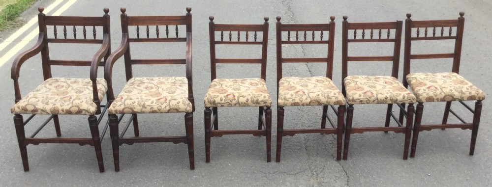 A set of six Edwardian mahogany dining chairs featuring upper spindle galleries, turned front legs, floral upholstered seats, and two matching carver armchairs. View II
