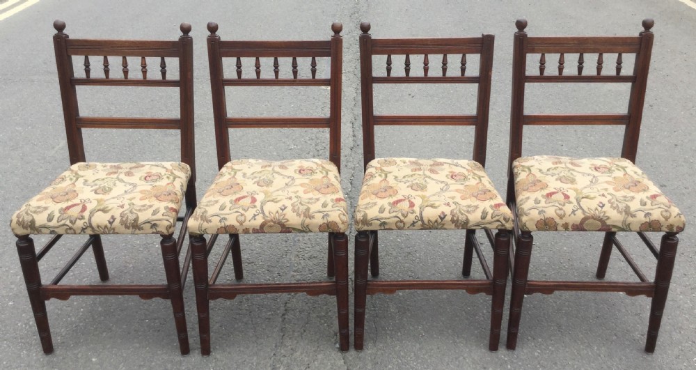 A set of six Edwardian mahogany dining chairs featuring upper spindle galleries, turned front legs, floral upholstered seats, and two matching carver armchairs. View III