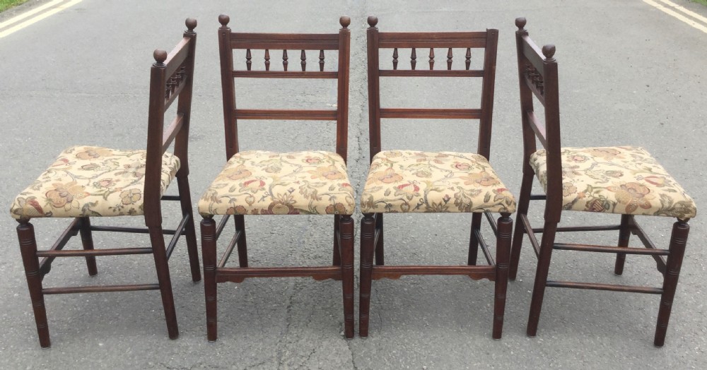 A set of six Edwardian mahogany dining chairs featuring upper spindle galleries, turned front legs, floral upholstered seats, and two matching carver armchairs. View VI