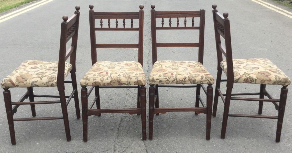 A set of six Edwardian mahogany dining chairs featuring upper spindle galleries, turned front legs, floral upholstered seats, and two matching carver armchairs. View VII