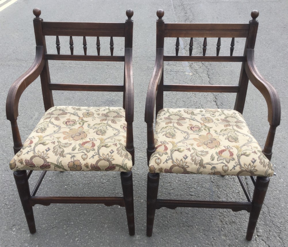 A set of six Edwardian mahogany dining chairs featuring upper spindle galleries, turned front legs, floral upholstered seats, and two matching carver armchairs. View IX