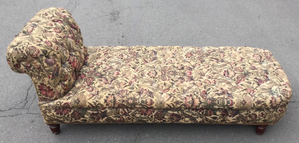 A Victorian upholstered daybed featuring deep-buttoned floral tapestry fabric with a scrolled end rest and turned wooden legs. View VIII