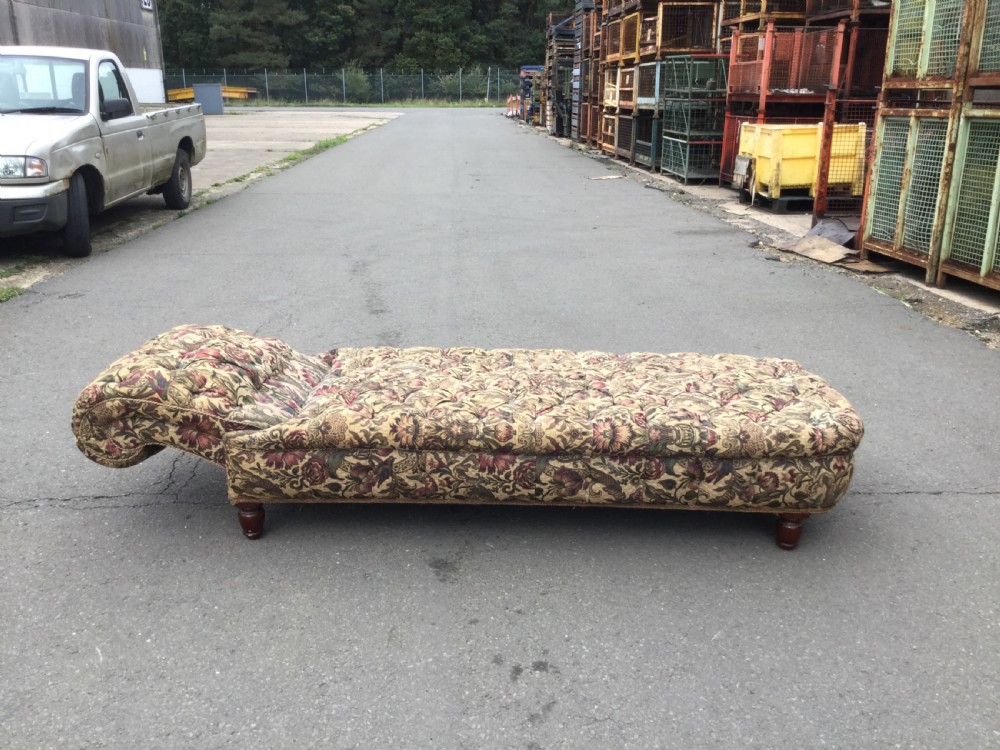 A Victorian upholstered daybed featuring deep-buttoned floral tapestry fabric with a scrolled end rest and turned wooden legs. View X