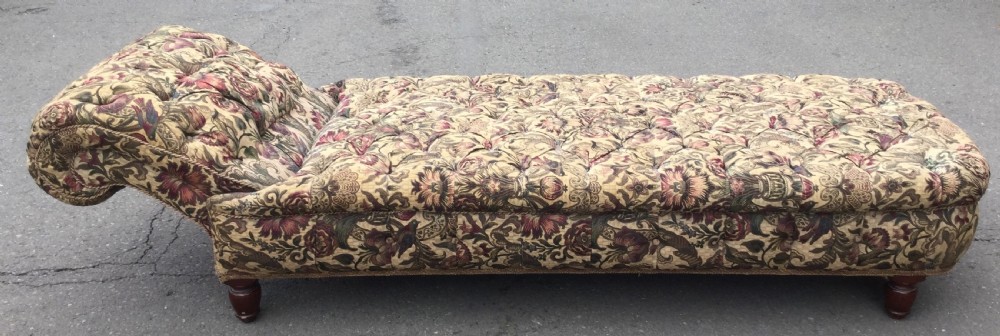 A Victorian upholstered daybed featuring deep-buttoned floral tapestry fabric with a scrolled end rest and turned wooden legs. View XII