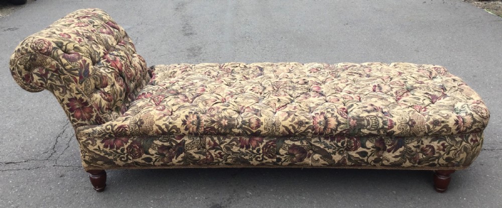 A Victorian upholstered daybed featuring deep-buttoned floral tapestry fabric with a scrolled end rest and turned wooden legs. View XIV
