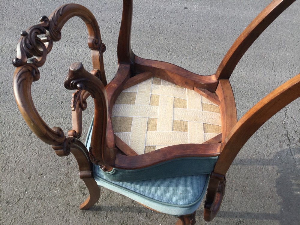 A set of eight Victorian walnut dining chairs featuring carved balloon backs, light blue velvet upholstered seats with central floral needlepoint designs, and cabriole front legs. View IX
