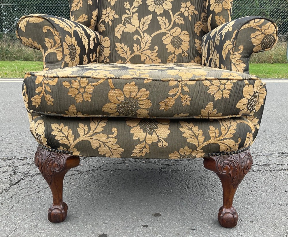 A wingback armchair upholstered in an olive green and gold floral fabric, featuring carved cabriole front legs with ball and claw feet. View II