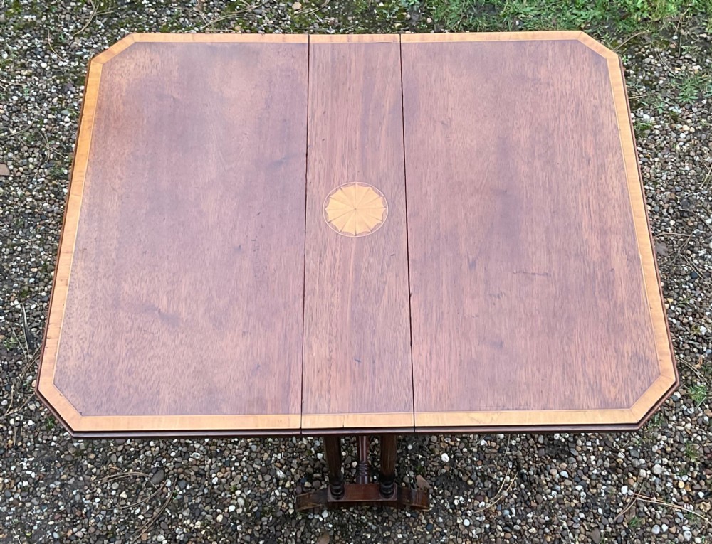 An Edwardian mahogany drop-leaf table featuring a central oval satinwood patera inlay, crossbanded borders, and slender turned legs. View V