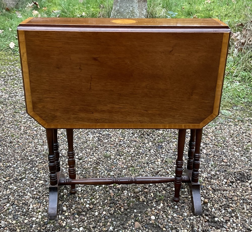 An Edwardian mahogany drop-leaf table featuring a central oval satinwood patera inlay, crossbanded borders, and slender turned legs. View VI