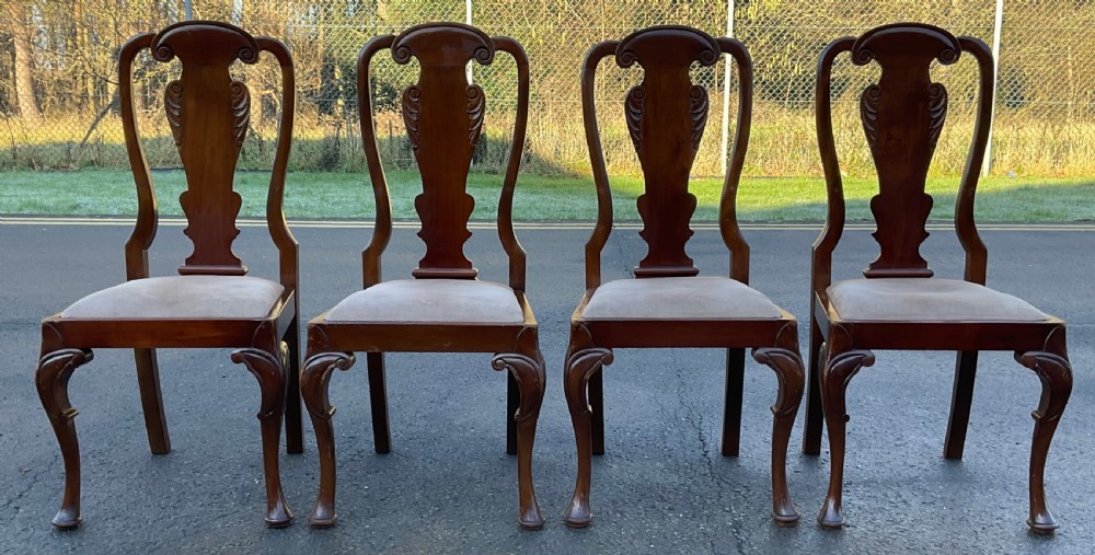 A set of four mahogany highback dining chairs featuring carved vase-shaped back splats, cabriole front legs, and neutral fabric upholstered seats. View III