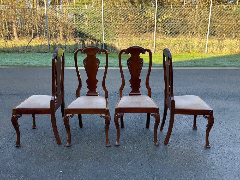 A set of four mahogany highback dining chairs featuring carved vase-shaped back splats, cabriole front legs, and neutral fabric upholstered seats. View IV