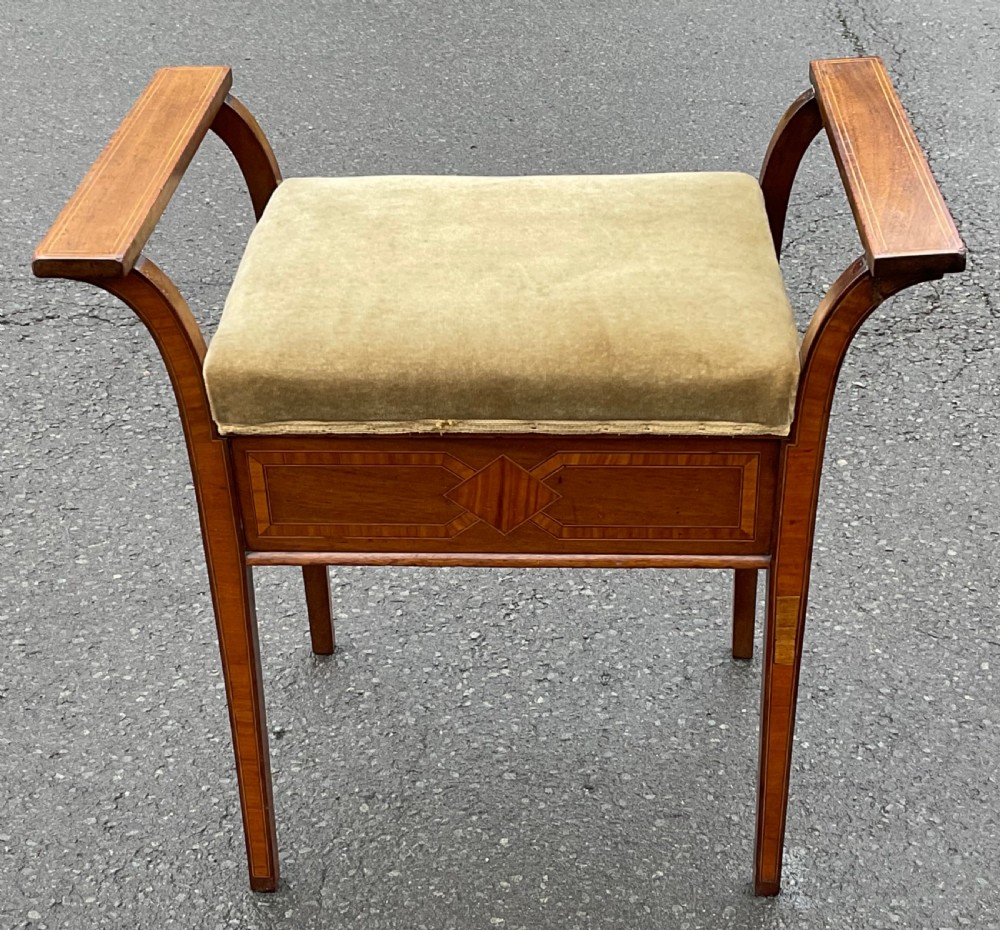 An Edwardian mahogany piano stool with curved side handles, green velvet upholstered seat, and geometric wood inlay on the apron. View III