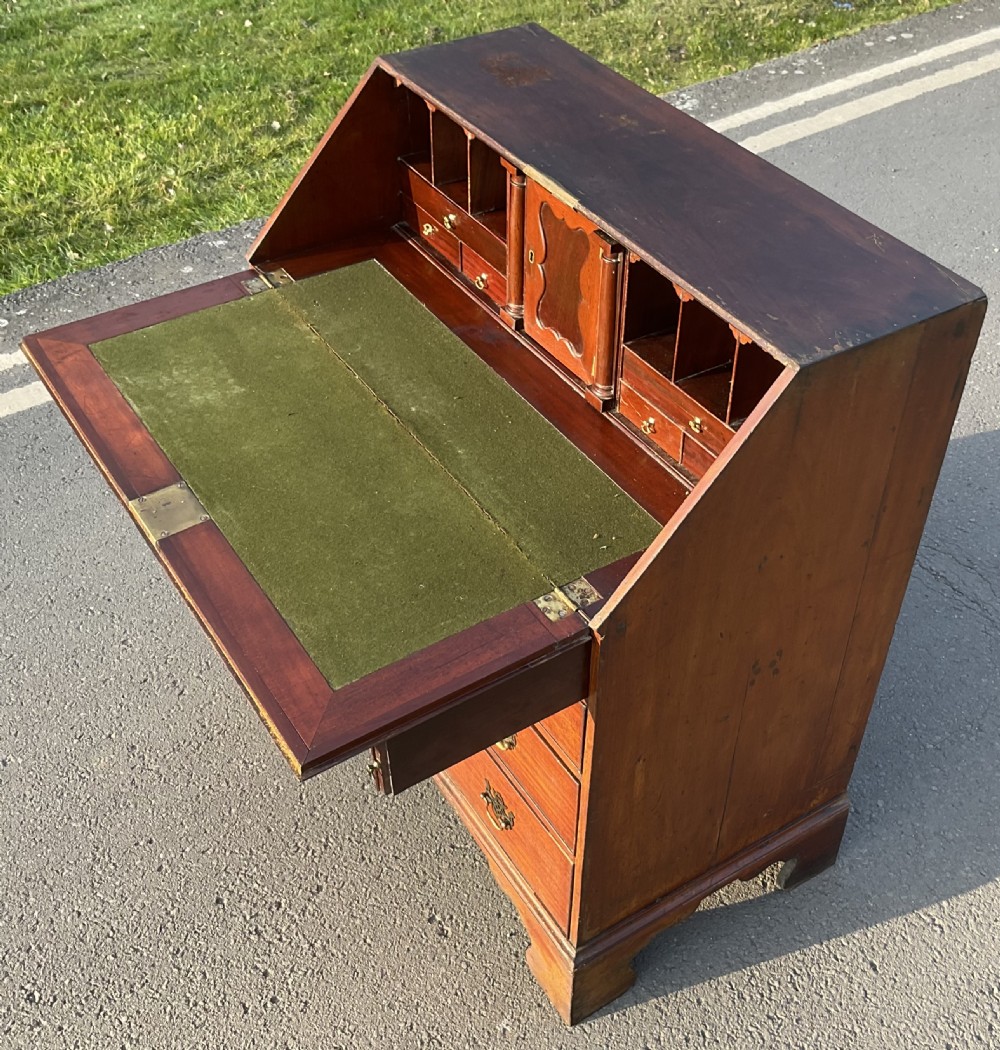 A Georgian mahogany slant-front writing bureau featuring four graduated drawers with pierced brass escutcheons and bracket feet. View VIII