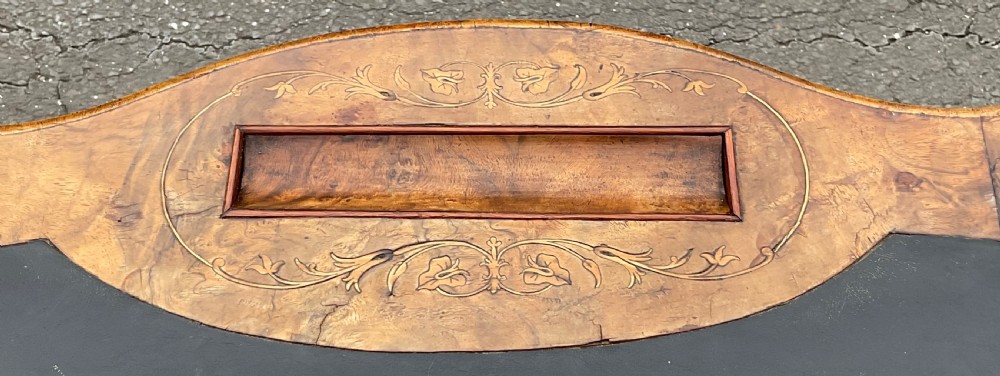 A Victorian burr walnut kidney-shaped writing table featuring an inset dark leather surface, floral marquetry inlay, carved turned supports, and a central stretcher base on castors. View XII