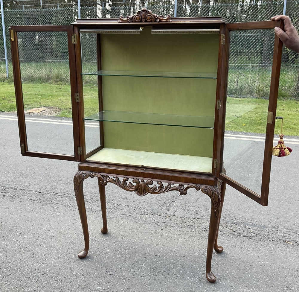A glazed burr walnut display cabinet with two glass doors, raised on carved cabriole legs with pad feet. View VI